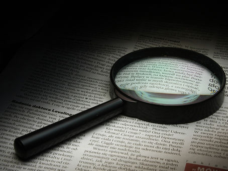 Magnifying glass highlighting text on a document representing investigation and evidence review
